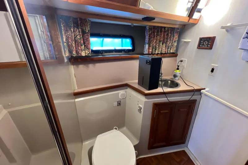Slide: The Image of 1987 Carver 4227 Cockpit Motor Yacht bathroom with sink, toilet, and window. - 73
