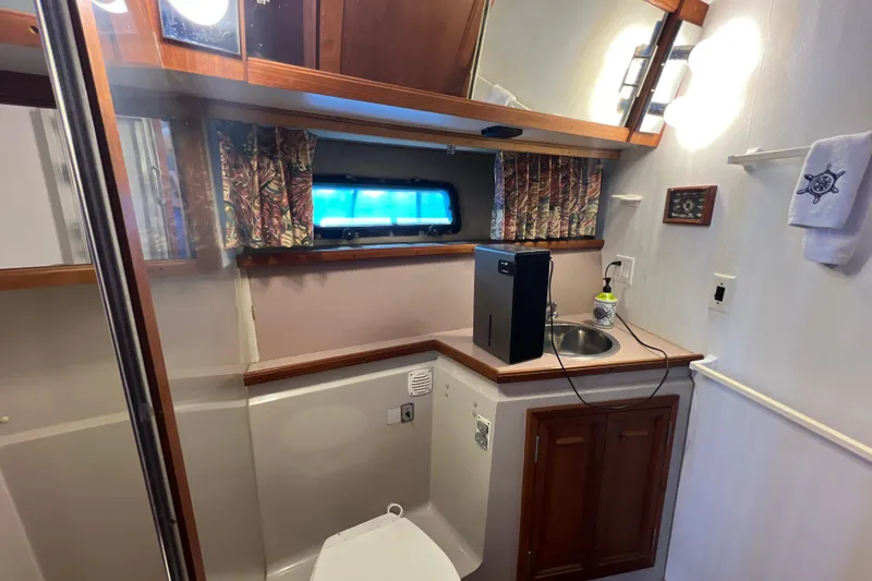 Slide: The Image of 1987 Carver 4227 Cockpit Motor Yacht bathroom with sink, toilet, and window. - 74
