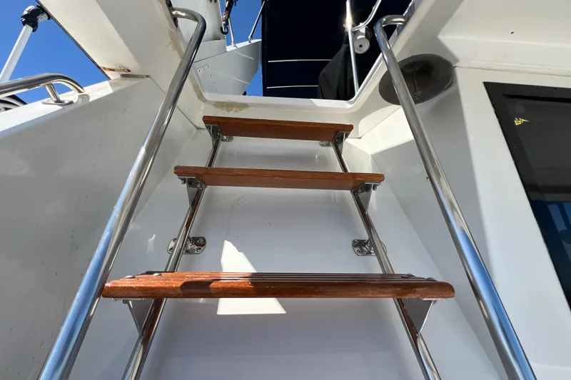 Slide: The Image of Staircase on 1987 Carver 4227 Cockpit Motor Yacht with wooden steps and metal railings. - 76