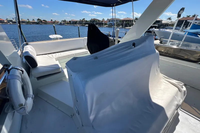 Slide: The Image of 1987 Carver 4227 Cockpit Motor Yacht with spacious seating, docked by waterfront homes. - 77