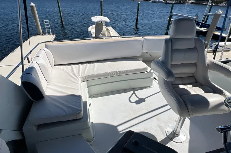 Slide: The Image of 1987 Carver 4227 Cockpit Motor Yacht with white seating, docked by the water. - 81