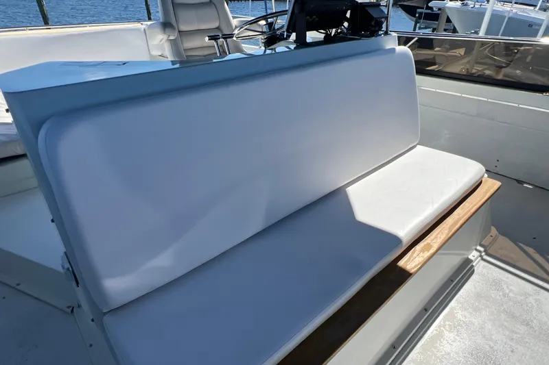 Slide: The Image of 1987 Carver 4227 Cockpit Motor Yacht seating area with white cushions and helm view. - 82