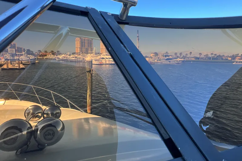 Slide: The Image of 1987 Carver 4227 Cockpit Motor Yacht docked, cityscape and marina in background. - 84
