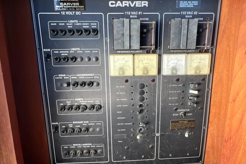 Slide: The Image of Control panel of a 1987 Carver 4227 Cockpit Motor Yacht, featuring various switches and meters. - 94