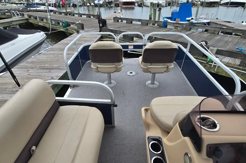Slide: The Image of 2019 TRACKER MARINE Bass Buggy pontoon boat docked at a marina. - 17