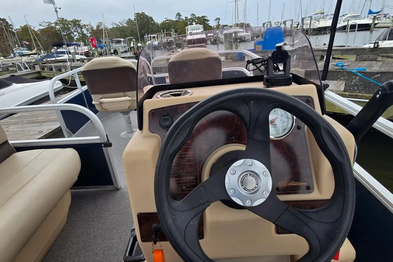 Slide: The Image of 2019 TRACKER MARINE Bass Buggy steering console at marina with docked boats. - 18