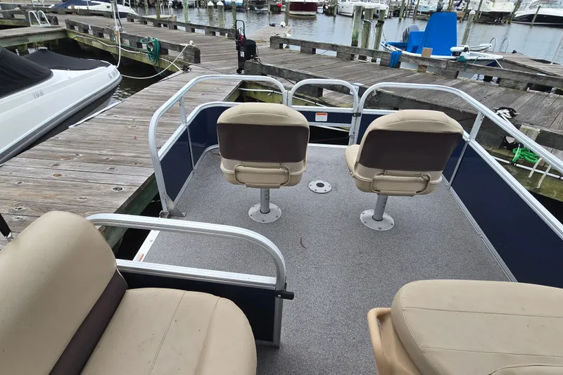 Slide: The Image of 2019 TRACKER MARINE Bass Buggy pontoon boat with beige seats docked at marina. - 20