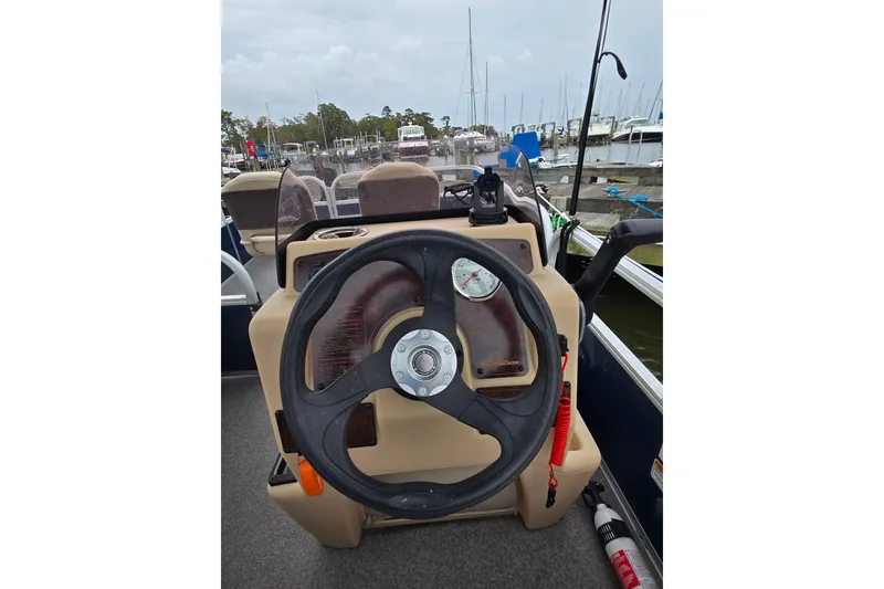 Slide: The Image of 2019 TRACKER MARINE Bass Buggy steering console at marina, featuring gauges and controls. - 21