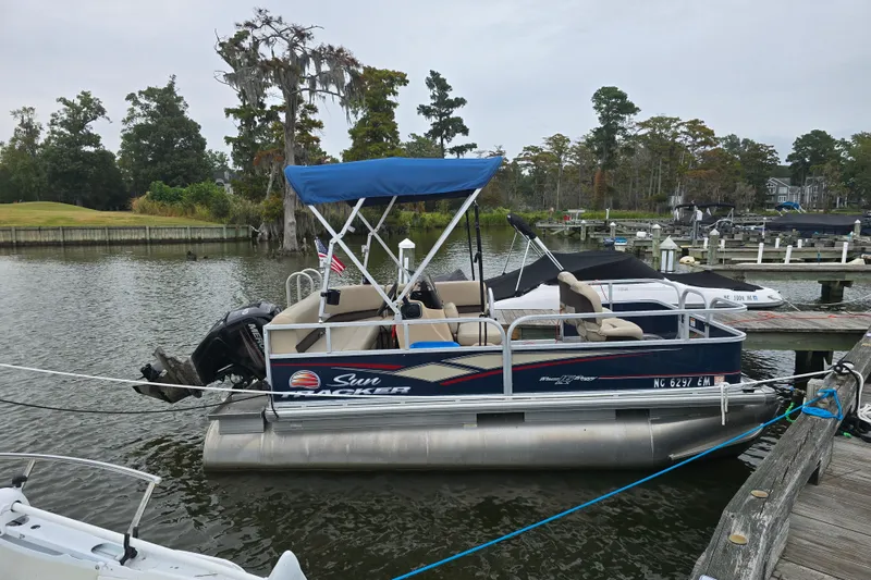 Slide: The Image of 2019 TRACKER MARINE Bass Buggy pontoon boat docked on a serene lake. - 3