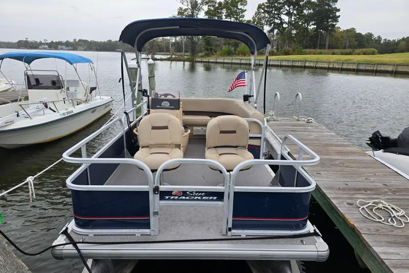 Slide: The Image of 2019 TRACKER MARINE Bass Buggy pontoon boat docked on a serene lake. - 6