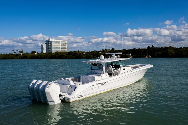 Slide: The Image of 2024 HCB 53 Sueños boat on calm water with a scenic backdrop. - 10