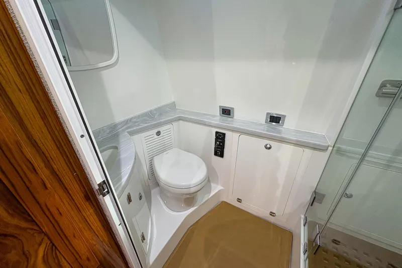 Slide: The Image of 2024 HCB 53 Sueños boat bathroom with modern fixtures and wooden accents. - 18