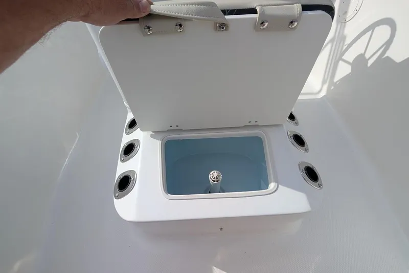 Slide: The Image of 2026 Robalo R160 Center Console livewell with open lid and rod holders. - 7