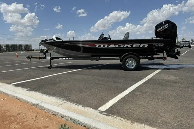 The Image of 2026 Tracker Pro Team 175 boat on trailer in parking lot under blue sky. - 0