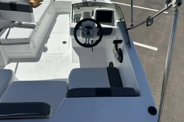Slide: The Image of 2025 Tahoe T16 boat interior with steering wheel and seating in a parking lot. - 10