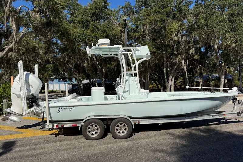 The Image of 2017 Yellowfin 24 Bay CE boat on trailer, parked under trees. - 0