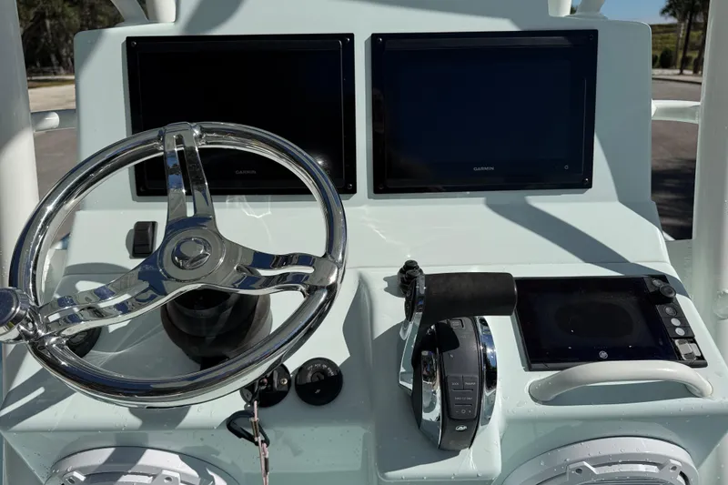 Slide: The Image of 2017 Yellowfin 24 Bay CE boat dashboard with dual Garmin screens and steering wheel. - 13