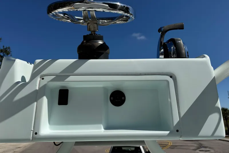Slide: The Image of 2017 Yellowfin 24 Bay CE boat console with steering wheel and controls under clear blue sky. - 20