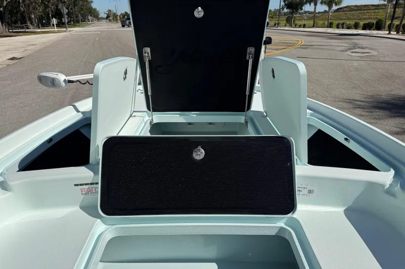 Slide: The Image of 2017 Yellowfin 24 Bay CE boat with open storage compartments on a sunny street. - 29