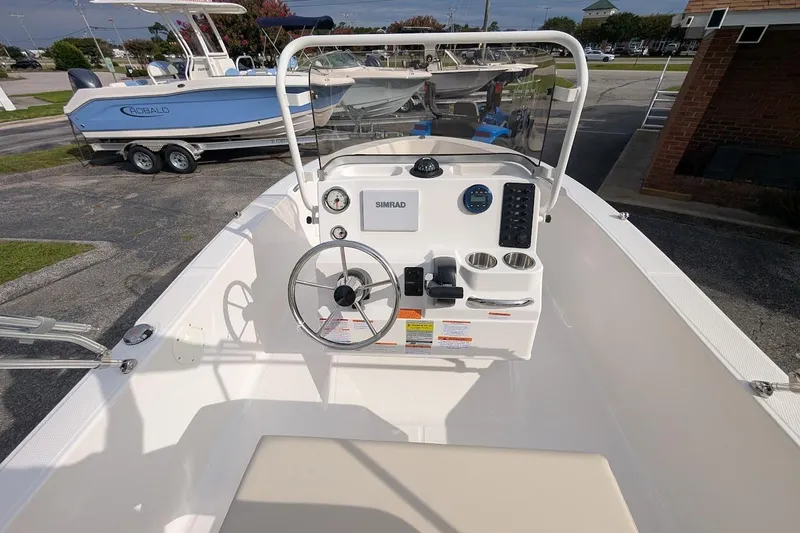 Slide: The Image of 2026 Robalo R160 Center Console boat with steering wheel and control panel. - 12