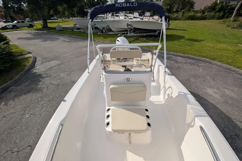Slide: The Image of 2026 Robalo R160 Center Console boat with seating, parked on a driveway. - 6
