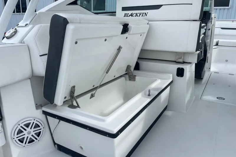 Slide: The Image of 2022 Blackfin 272 DC boat with open storage compartment and sleek white interior design. - 16