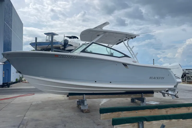 Slide: The Image of 2022 Blackfin 272 DC boat on dry dock, cloudy sky background. - 3