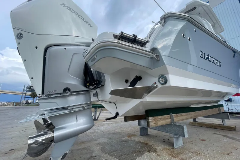 Slide: The Image of 2022 Blackfin 272 DC boat with Mercury outboard engine, docked on a stand. - 5