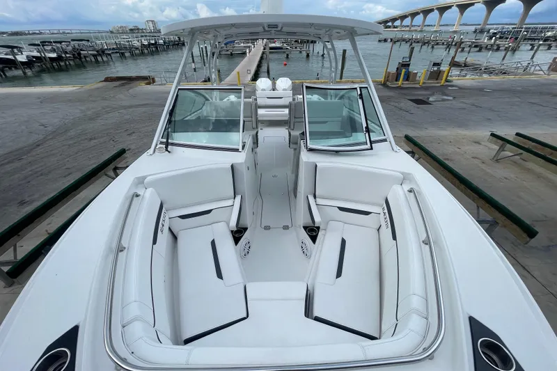 Slide: The Image of 2022 Blackfin 272 DC boat with spacious seating, docked near a marina. - 6
