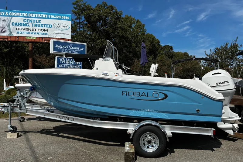 The Image of 2026 Robalo R180 Center Console boat on trailer, displayed outdoors. - 1
