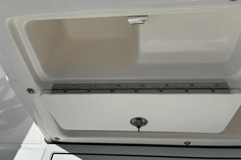 Slide: The Image of 2026 Robalo R180 Center Console storage compartment with secure latch and hinge. - 6