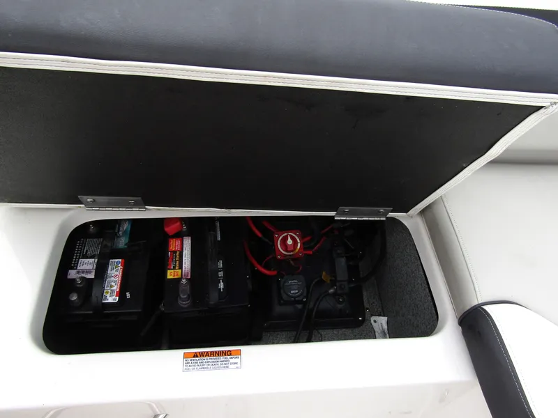 Slide: The Image of 2024 Starcraft SVX 231 OB DH boat battery compartment with wiring and safety label. - 28