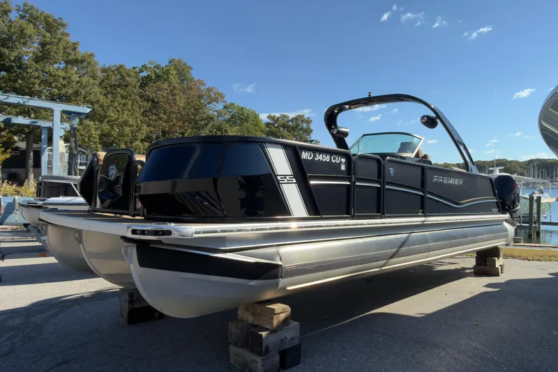 The Image of 2024 Premier Supersport pontoon boat on display, docked near a marina under a clear blue sky. - 0