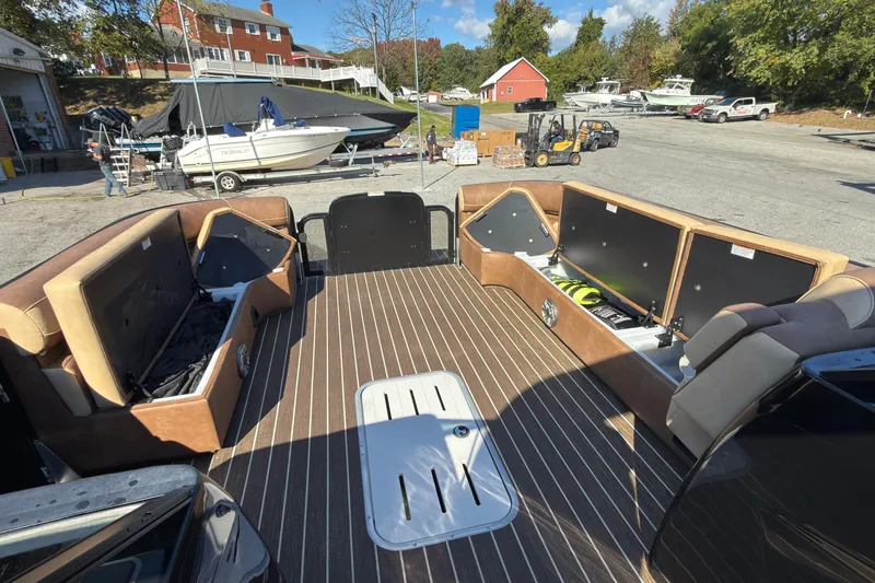 Slide: The Image of 2024 Premier Supersport boat interior with open storage compartments, docked near other boats. - 12