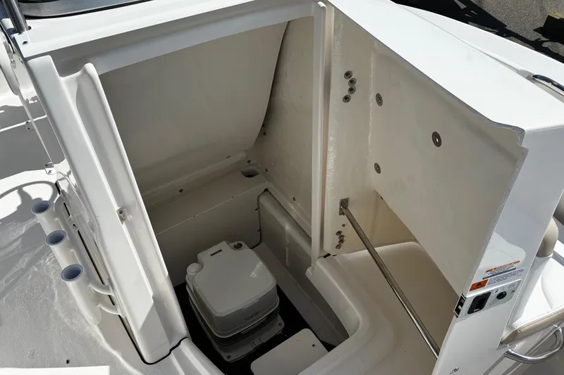 Slide: The Image of 2026 Robalo R180 Center Console boat interior storage compartment with portable toilet. - 14