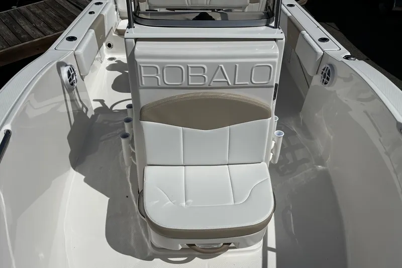 Slide: The Image of 2026 Robalo R180 Center Console boat interior with cushioned seating and rod holders. - 15