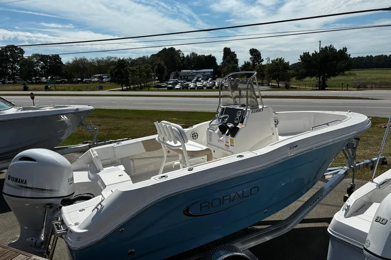 Slide: The Image of 2026 Robalo R180 Center Console boat with Yamaha engine, displayed outdoors. - 2