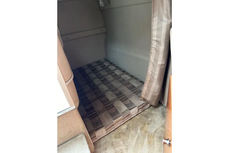 Slide: The Image of 2007 Chaparral Signature 240 cabin interior with patterned mattress and curtain. - 8