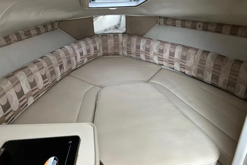 Slide: The Image of 2007 Chaparral Signature 240 cabin interior with beige seating and patterned cushions. - 9