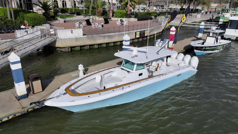 Slide: The Image of 2025 HCB Lujo boat docked at marina, featuring sleek design and multiple engines. - 2