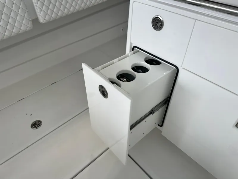 Slide: The Image of 2025 HCB Lujo boat with open storage drawer and cup holders. - 38