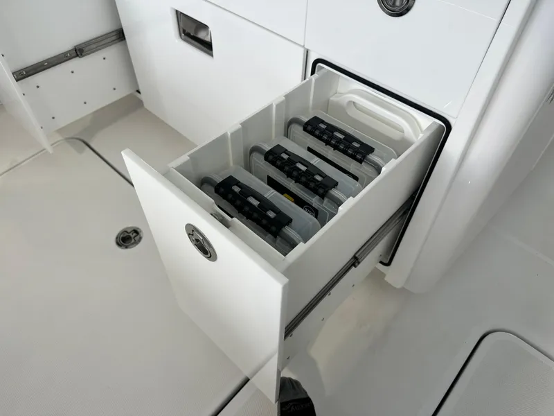 Slide: The Image of HCB Lujo 2025 boat storage drawer with organized tackle boxes. - 39