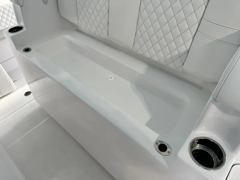 Slide: The Image of 2025 HCB Lujo boat interior with white quilted seating and cup holders. - 42