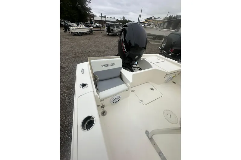 Slide: The Image of 2005 Pathfinder TRS boat with Mercury engine, parked outdoors, showcasing seating and storage compartments. - 18