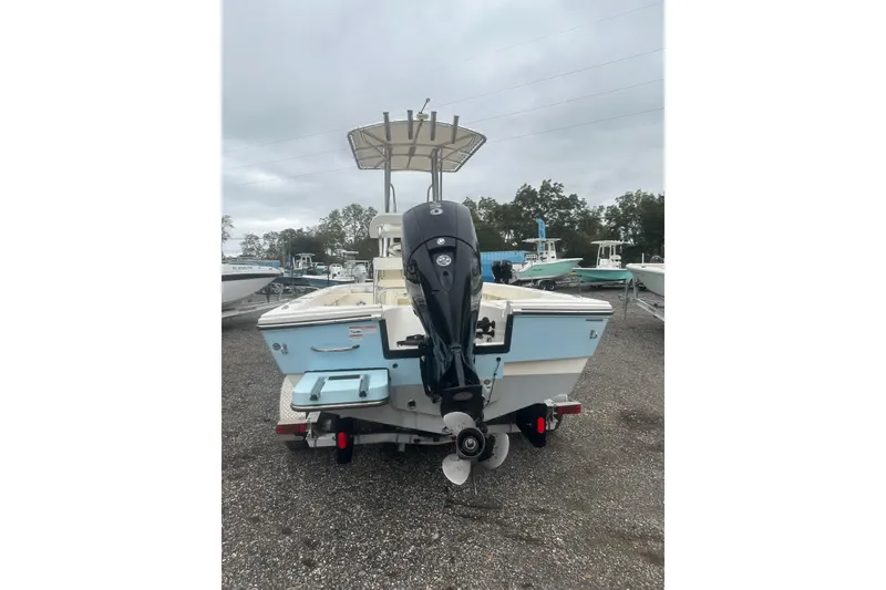 Slide: The Image of Pathfinder 2005 TRS boat, rear view with outboard motor, parked on gravel. - 4
