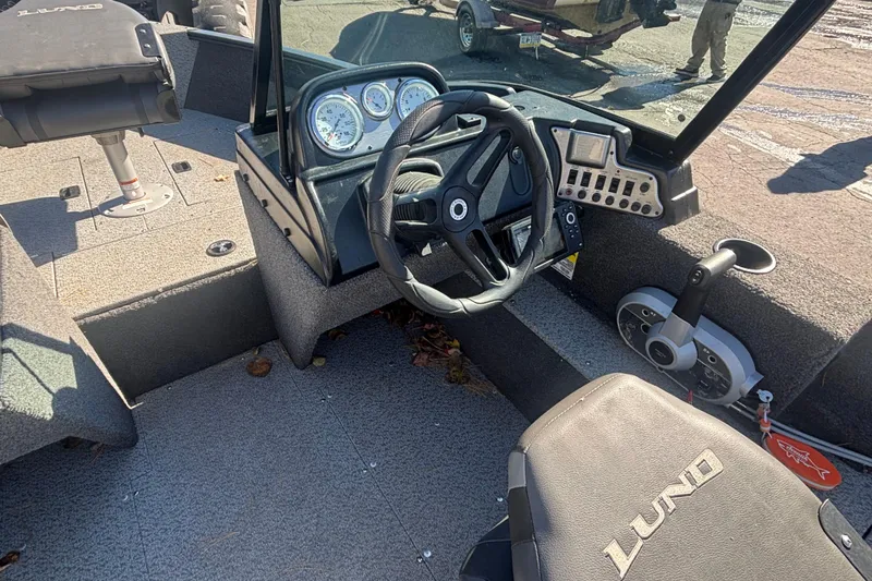 Slide: The Image of 2021 Lund 1650 Rebel XL Sport boat interior with steering wheel and control panel. - 10
