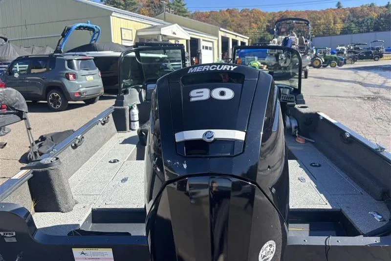 Slide: The Image of 2021 Lund 1650 Rebel XL Sport boat with Mercury 90 engine in a marina setting. - 5