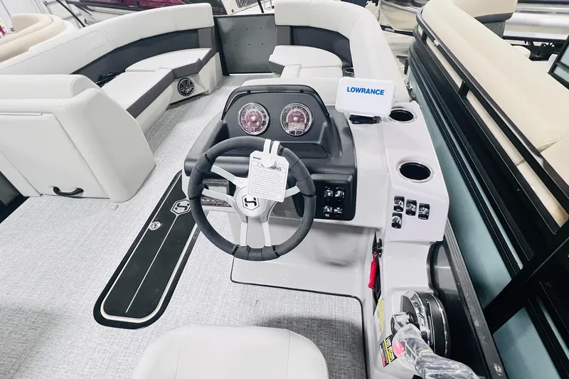 Slide: The Image of 2025 Harris Cruiser 230 boat interior with steering wheel and seating area. - 14