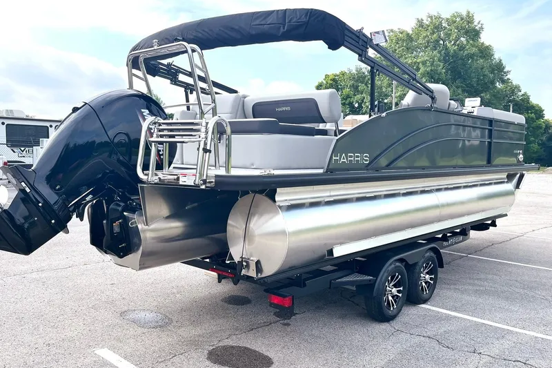 Slide: The Image of 2025 Harris Cruiser 230 pontoon boat on trailer, featuring sleek design and powerful outboard motor. - 3