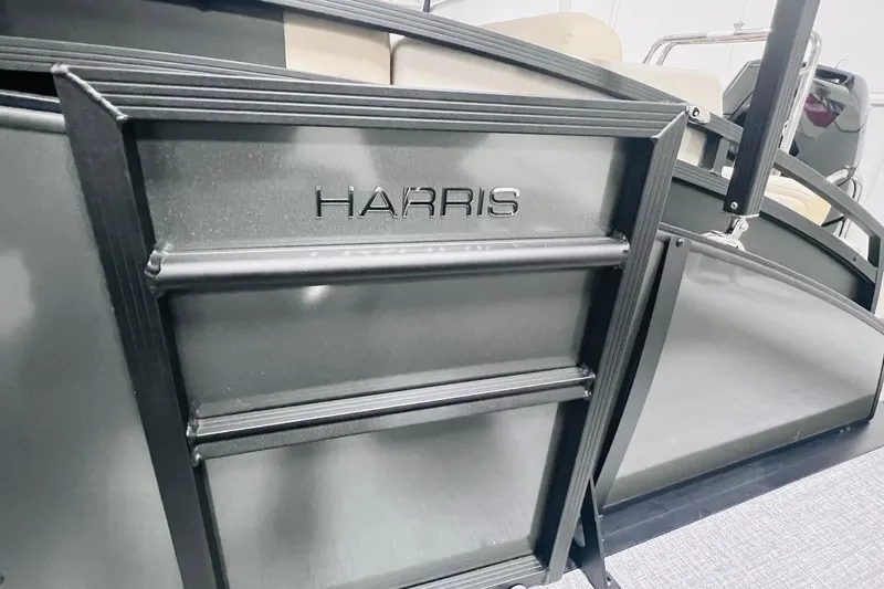 Slide: The Image of 2025 Harris Cruiser 230 boat detail with sleek metal design and embossed logo. - 37